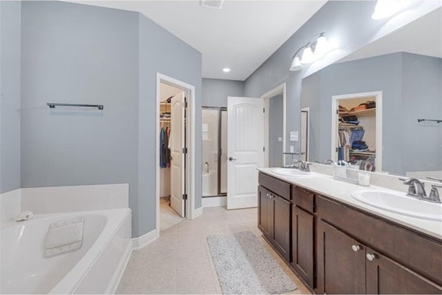 bathroom featuring tile patterned flooring, vanity, and a bathtub