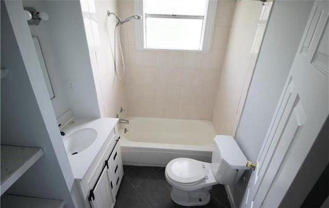 full bathroom featuring toilet, vanity, tile patterned floors, and tiled shower / bath