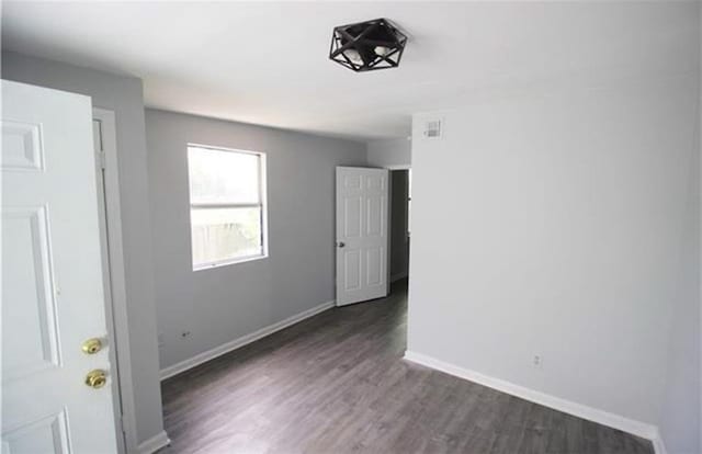 unfurnished bedroom with dark wood-type flooring