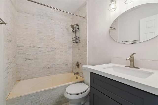 full bathroom featuring tiled shower / bath, vanity, and toilet