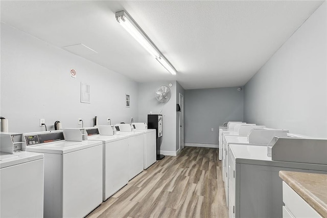 laundry area featuring washing machine and dryer and light hardwood / wood-style flooring