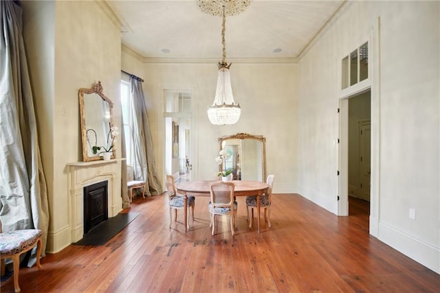 dining room with dark hardwood / wood-style flooring, crown molding, and a notable chandelier