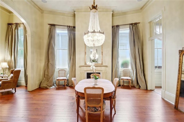 dining space with hardwood / wood-style flooring, crown molding, and plenty of natural light