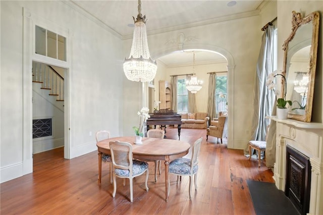 dining room with hardwood / wood-style floors, crown molding, and a chandelier