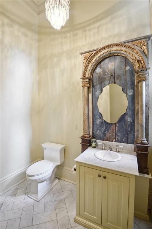 bathroom with toilet, a chandelier, and vanity