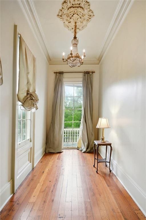 living area with ornamental molding, a chandelier, and hardwood / wood-style floors