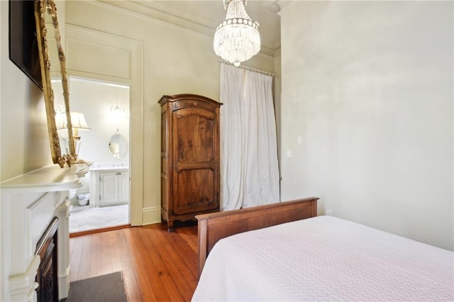 bedroom featuring an inviting chandelier, hardwood / wood-style flooring, and ornamental molding