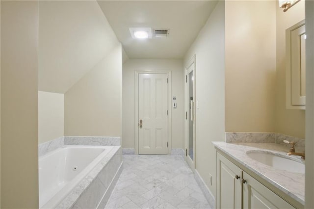 bathroom featuring vanity and tiled bath