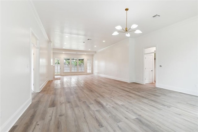 unfurnished living room with a notable chandelier, light hardwood / wood-style floors, and crown molding