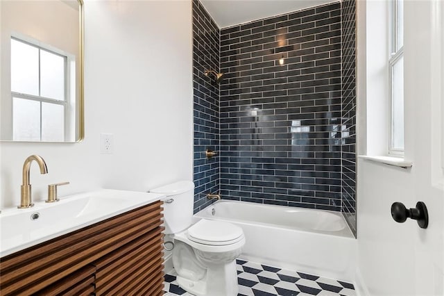 full bathroom featuring vanity, tiled shower / bath combo, and toilet