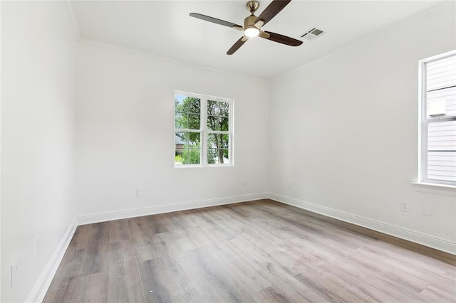 spare room with ceiling fan, crown molding, and light wood-type flooring