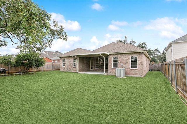 rear view of house with a patio area, a yard, and central AC unit