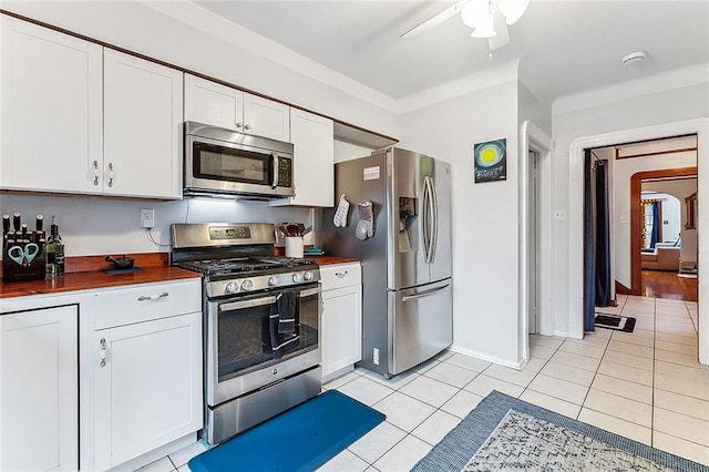 kitchen featuring white cabinets, ceiling fan, light tile patterned floors, and appliances with stainless steel finishes