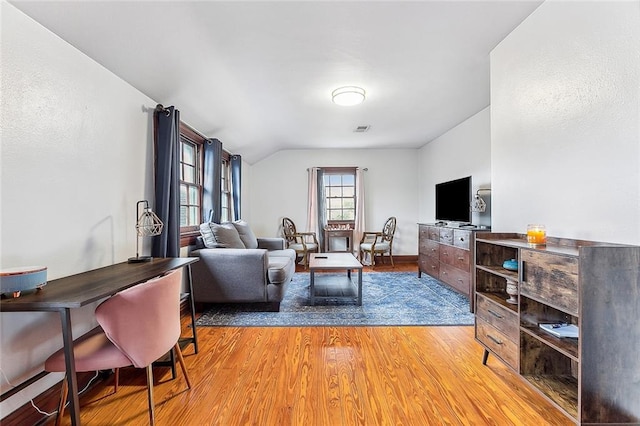 living room with light hardwood / wood-style floors and lofted ceiling