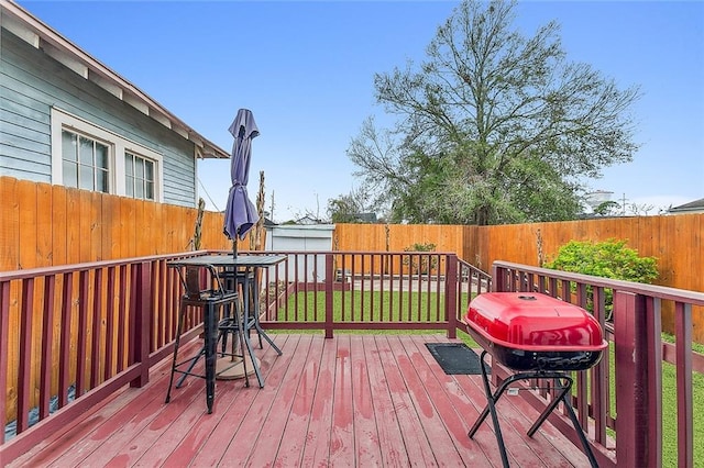 wooden deck featuring a yard and grilling area