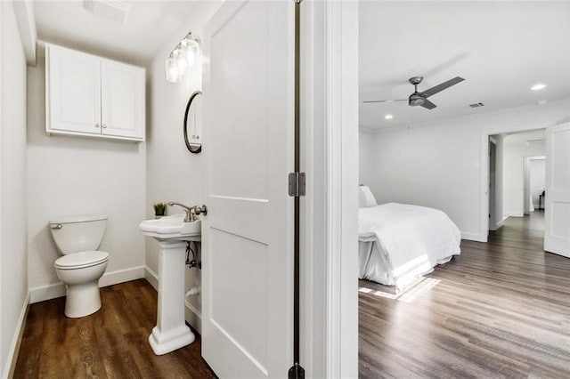 bathroom with wood-type flooring, toilet, ceiling fan, and sink