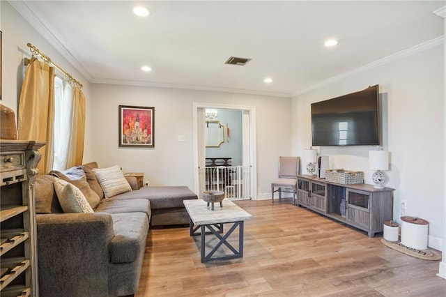 living room featuring light wood-type flooring and crown molding