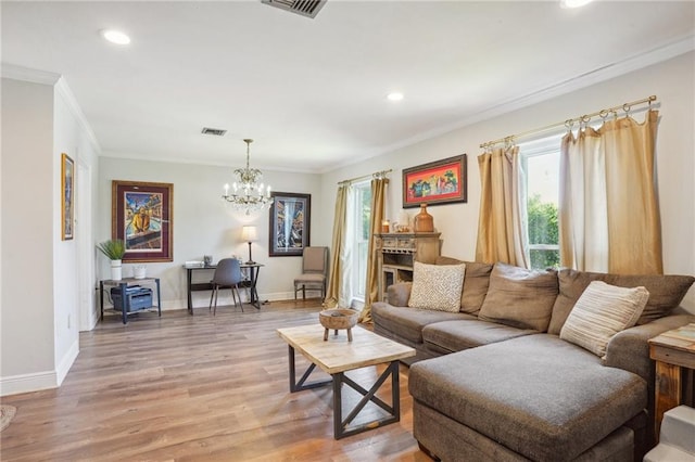 living room featuring a chandelier, hardwood / wood-style flooring, and ornamental molding