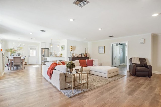 living room with a notable chandelier and light hardwood / wood-style floors