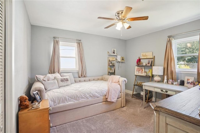 bedroom with multiple windows, ceiling fan, and carpet floors