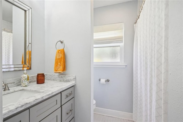 bathroom featuring walk in shower, vanity, and toilet