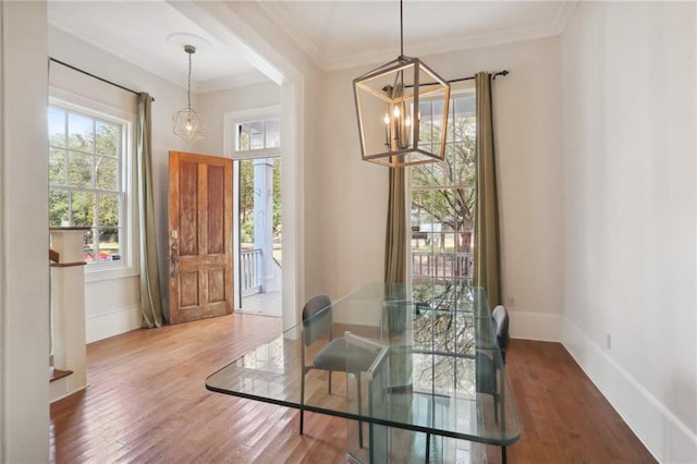 dining space with a notable chandelier, wood-type flooring, and ornamental molding