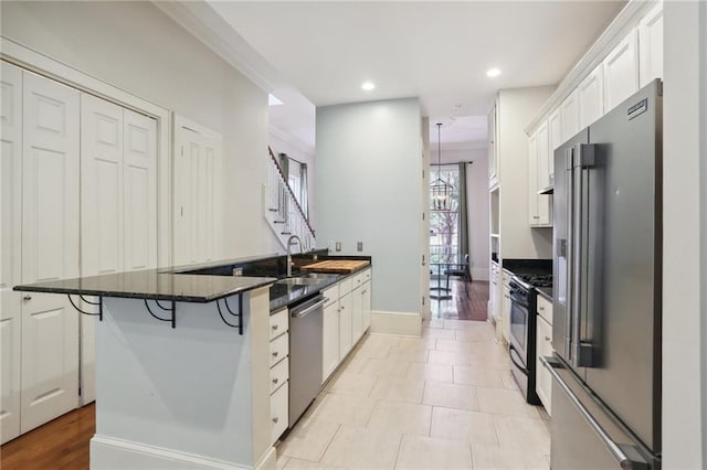 kitchen with sink, light wood-type flooring, a kitchen bar, white cabinetry, and stainless steel appliances