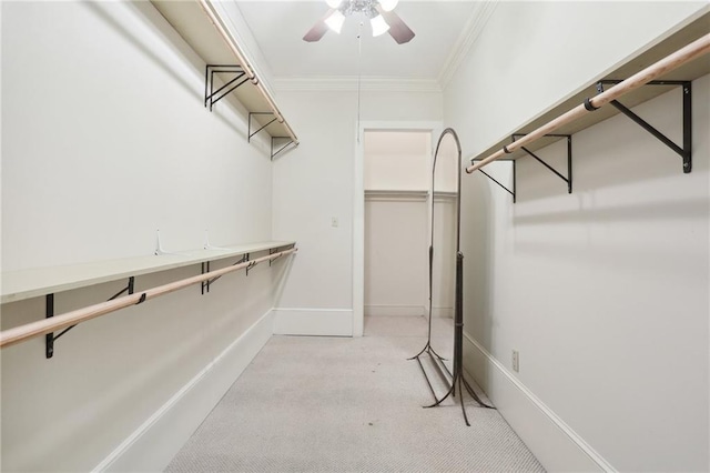 spacious closet with light carpet and ceiling fan