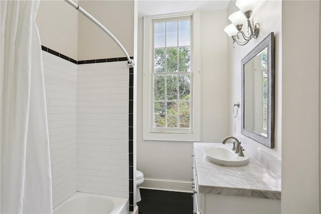 full bathroom with a wealth of natural light, shower / bath combo with shower curtain, vanity, and toilet