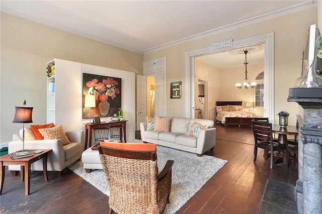 living room featuring a chandelier, dark hardwood / wood-style flooring, and crown molding