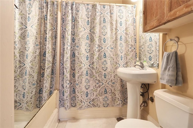 bathroom featuring curtained shower, toilet, and sink