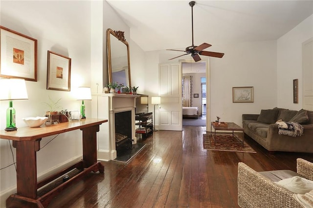 living room with ceiling fan, dark hardwood / wood-style flooring, and vaulted ceiling