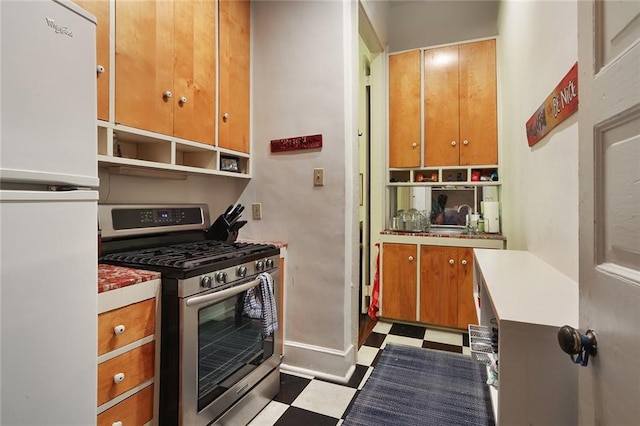 kitchen featuring sink, white refrigerator, and stainless steel gas range