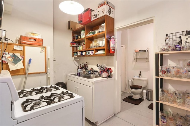 interior space with white cabinets, light wood-type flooring, white appliances, and sink