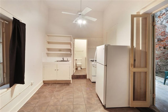 kitchen with ceiling fan, light tile patterned floors, high vaulted ceiling, white fridge, and white cabinetry