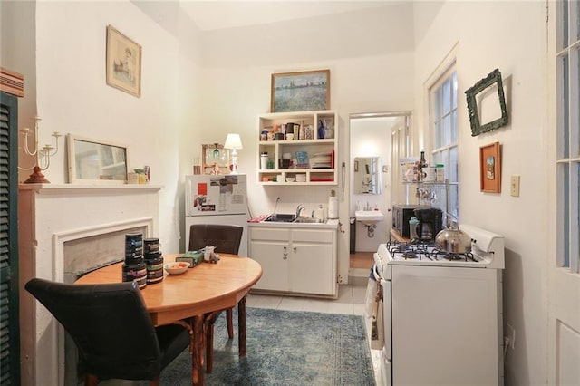 kitchen featuring white cabinetry, white appliances, sink, and light tile patterned floors