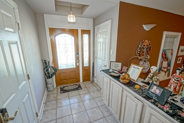 tiled entryway featuring a tray ceiling