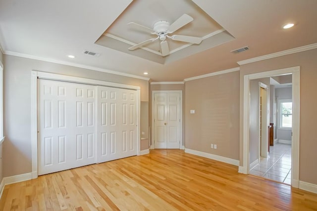 unfurnished bedroom with two closets, light hardwood / wood-style floors, ceiling fan, and ornamental molding