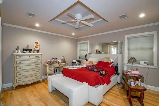 bedroom featuring a tray ceiling, light hardwood / wood-style flooring, ceiling fan, and ornamental molding