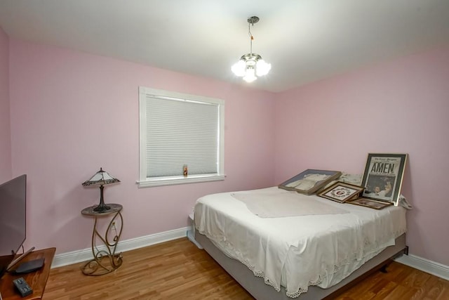 bedroom featuring hardwood / wood-style floors and an inviting chandelier