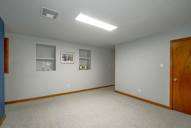 carpeted empty room featuring built in features