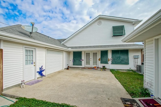 doorway to property with french doors, cooling unit, and a garage