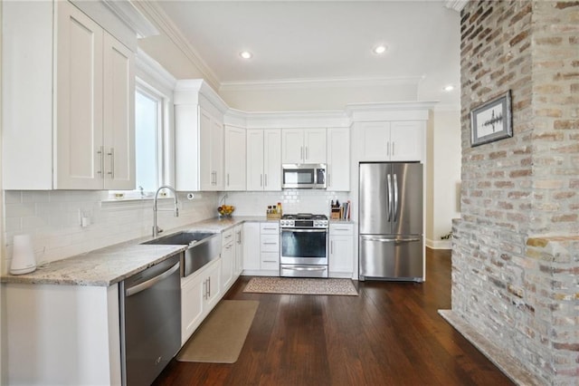 kitchen with light stone countertops, white cabinetry, stainless steel appliances, and dark wood-type flooring