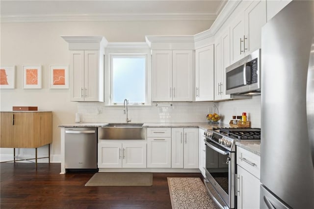 kitchen featuring white cabinetry, sink, stainless steel appliances, light stone counters, and dark hardwood / wood-style floors