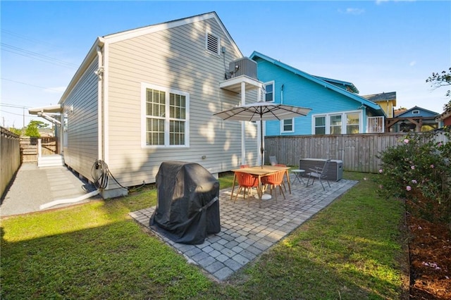 rear view of property featuring a patio and a lawn