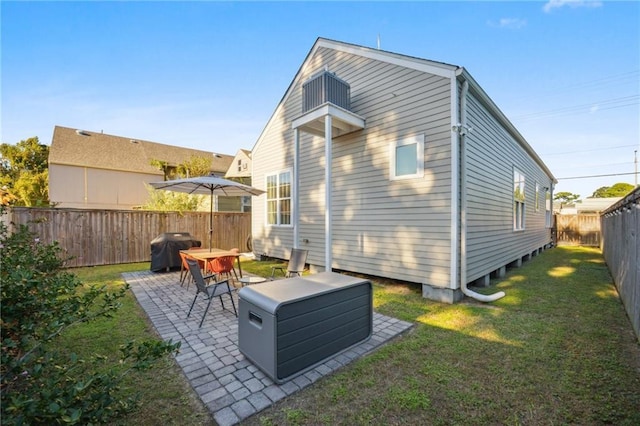 back of house with a patio and a lawn