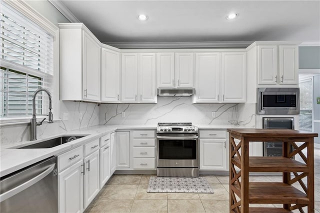 kitchen featuring white cabinets, a wealth of natural light, sink, and appliances with stainless steel finishes