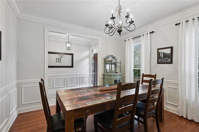 dining room with an inviting chandelier, dark wood-type flooring, and ornamental molding