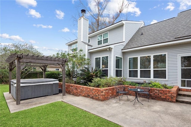 back of property with a pergola, a lawn, a patio, and a hot tub