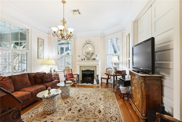 living room featuring hardwood / wood-style flooring, an inviting chandelier, and a healthy amount of sunlight